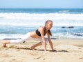 Smiling active young woman doing sports excercises on the beach