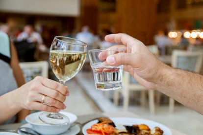 Man and woman are clanging glasses in restaurant