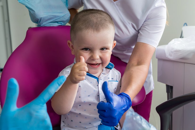 Little boy in dentistry smiling and showing thumb up