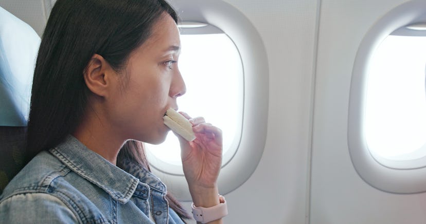 Woman eating sandwich on plane