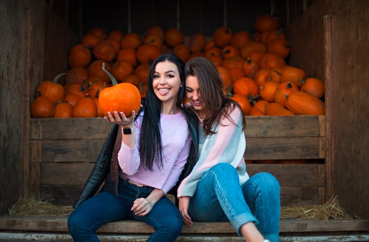 Instagram captions for pumpkin patch photos are perfect for these two girls in jeans sitting next t...