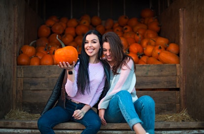 Instagram captions for pumpkin patch photos are perfect for  these two girls in jeans sitting next t...