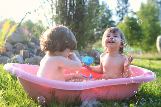 twins boy and girl in bath water outdoor