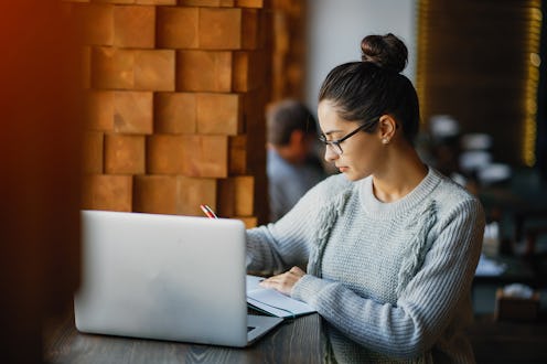 brunetter woman working on her laptop at a restaurant