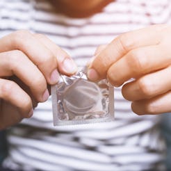 Condom ready to use in female hand, give condom safe sex concept on the bed Prevent infection and Co...