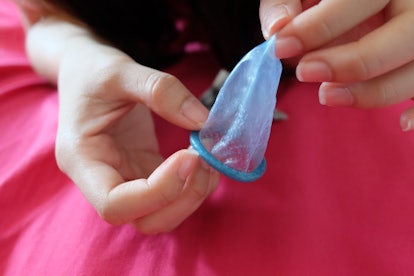 Condom and a women on white shirt It use to reduce the probability of pregnancy or safe sex.