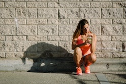 Female athlete taking a workout rest for drinking green detox smoothie.