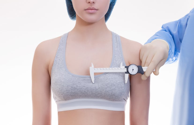 A doctor measuring a womans breast size who has experienced a sudden shift in breast shape