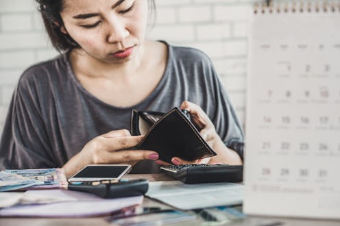 stress Asian woman open empty wallet looking for money for debt