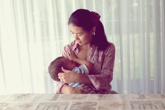 Mother breastfeeding her baby. Mom nursing baby. Vintage photo mom and baby son.