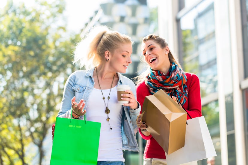 Friends, two women, shopping with bags in city