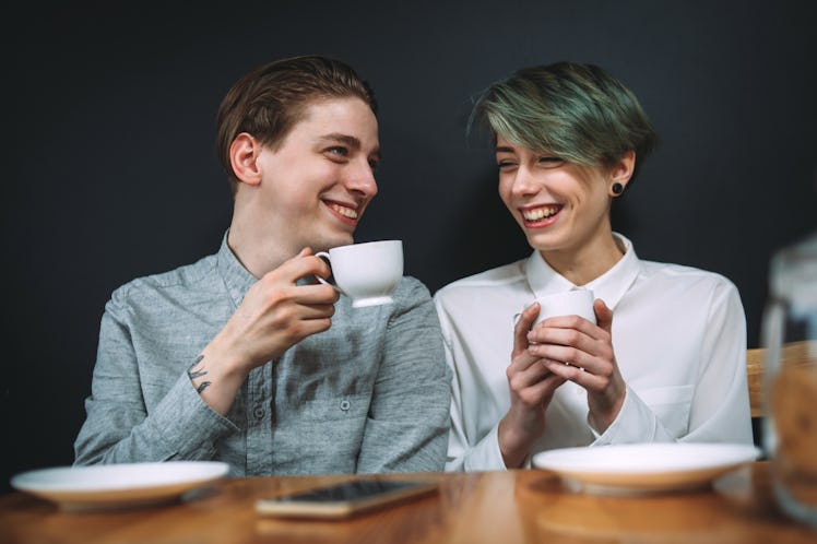 couple love relationship. girlfriend and boyfriend drinking coffee in a bar. talking and laughing on...