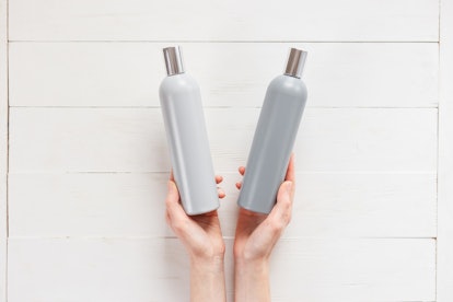 The woman chooses one of the two shampoos in the bottle. The concept of beau.ty and choice of cosmet...
