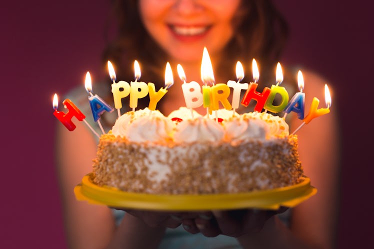 Hands of young woman holding birthday cake selective focus