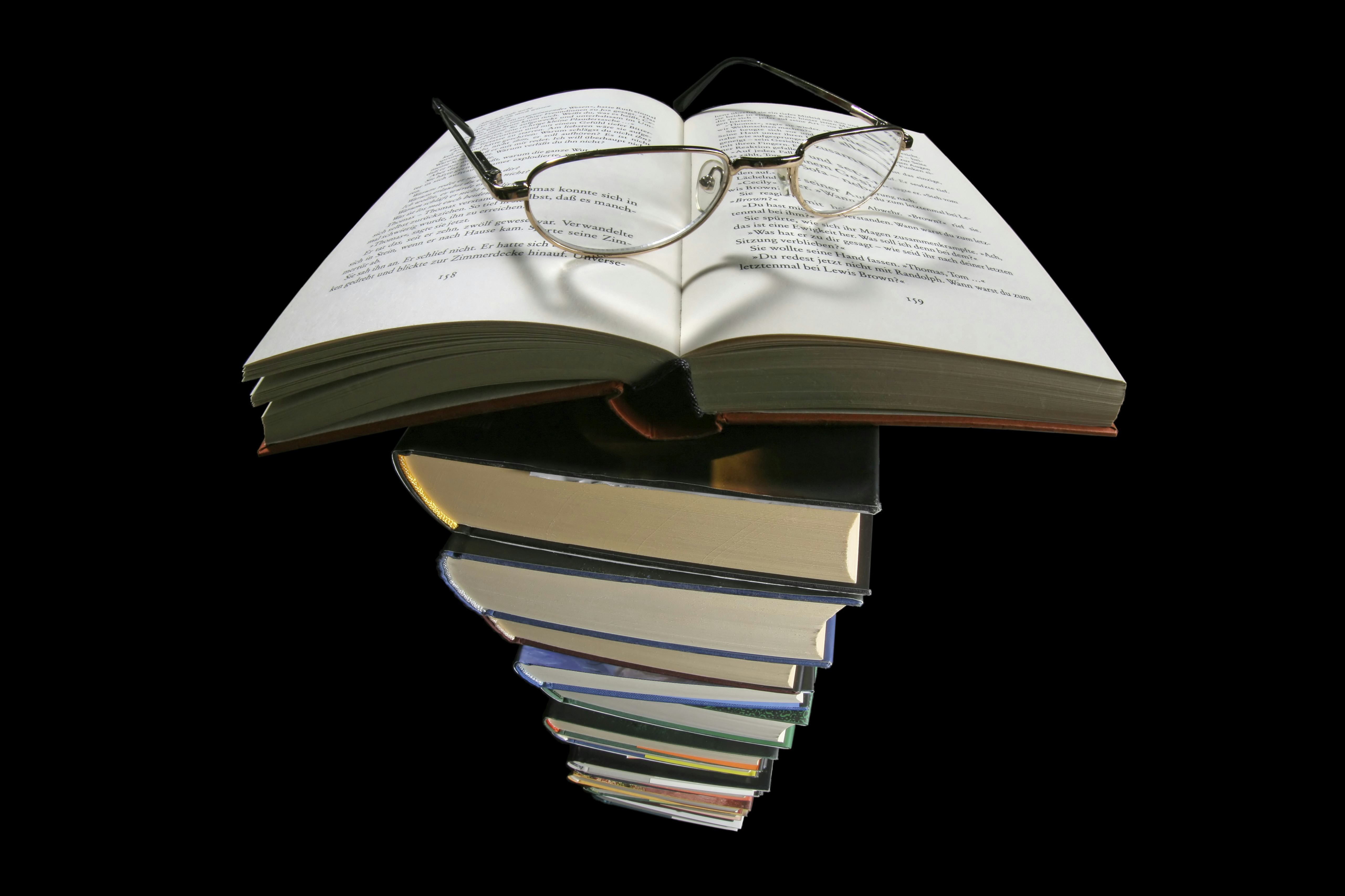 Book, pair of reading glasses, heart-shaped shadow, pile of books