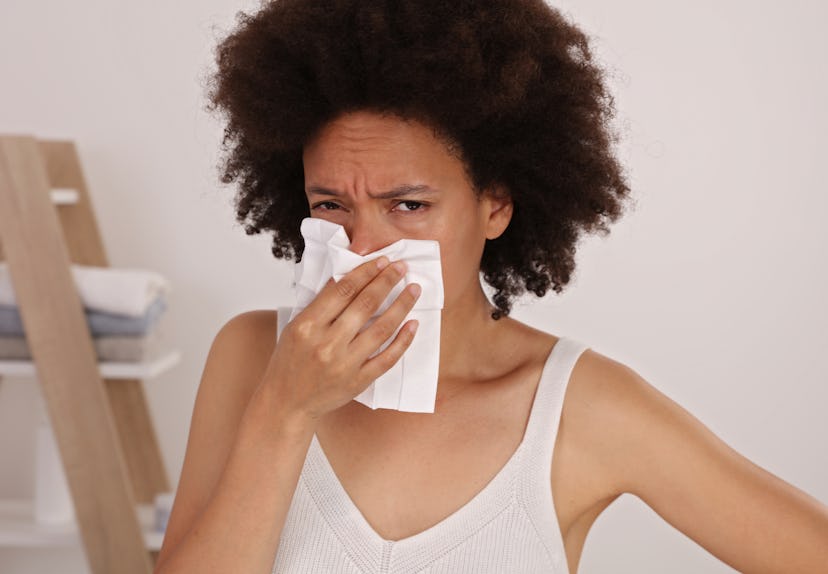 Woman sneezing in to tissue/ Blowing Nose In Handkerchief . Flu and Allegie.