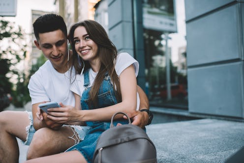 Happy couple in love enjoying free time for listening songs podcast and sharing impressions to follo...