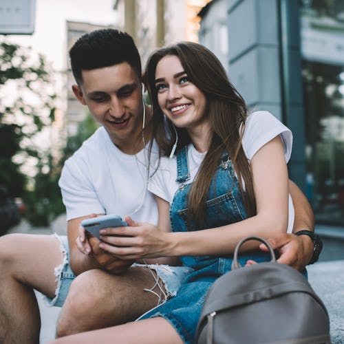 Happy couple in love enjoying free time for listening songs podcast and sharing impressions to follo...