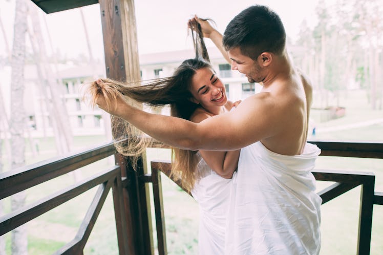 couple in love wrapped in a towel, hugging on the balcony