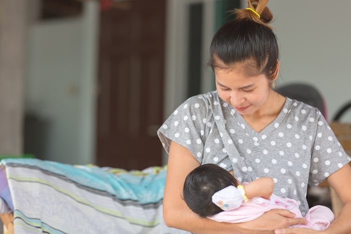 Beautiful happy mother breastfeeding her baby.