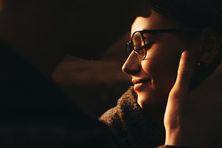 Anonymous guy gently touching face of beautiful female in stylish glasses.Unrecognizable man touchin...