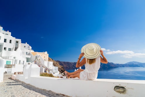 Luxury travel vacation woman looking at view on Santorini island in Greece. Amazing view of sea and ...