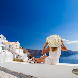 Luxury travel vacation woman looking at view on Santorini island in Greece. Amazing view of sea and ...