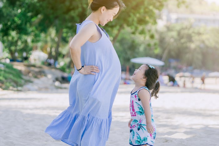 Photo of Happy family.Pregnant mother and daughter smiling relaxing and playing on the beach,Happy p...