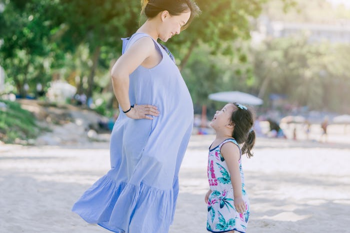 Photo of Happy family.Pregnant mother and daughter smiling relaxing and playing on the beach,Happy p...