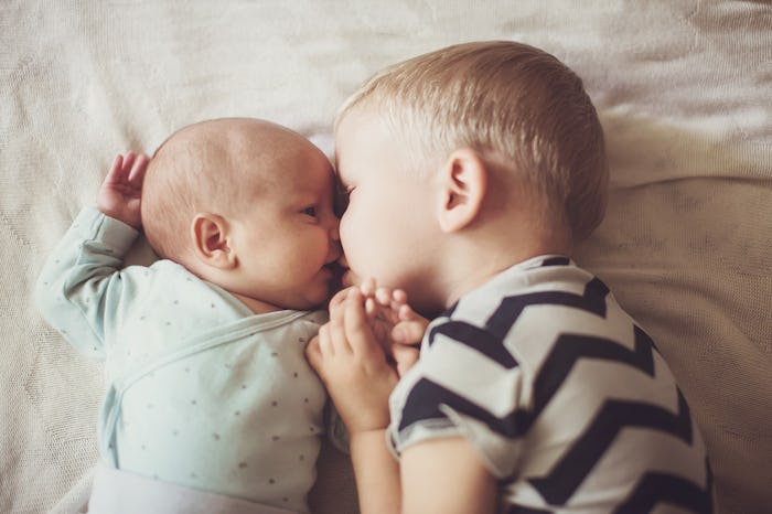 older brother kisses younger brother