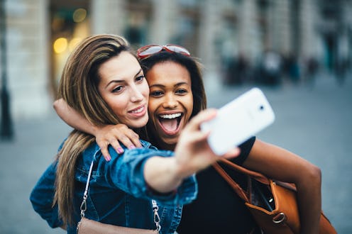 Multi ethnic Friends having fun in city taking selfie