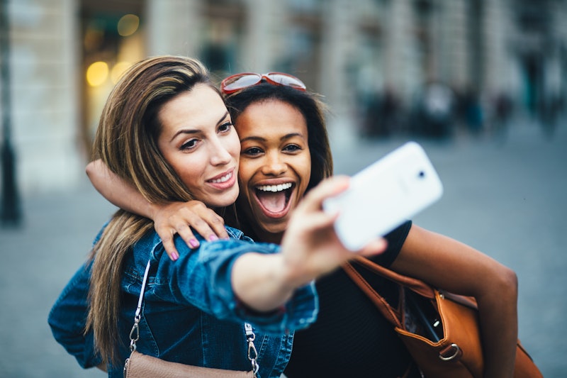 Multi ethnic Friends having fun in city taking selfie