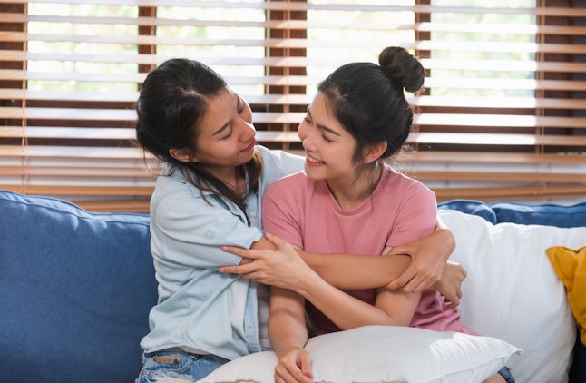 Happy asian lesbian couple hug each other with love on sofa at living room at home,LGBTQ lifestyle concept