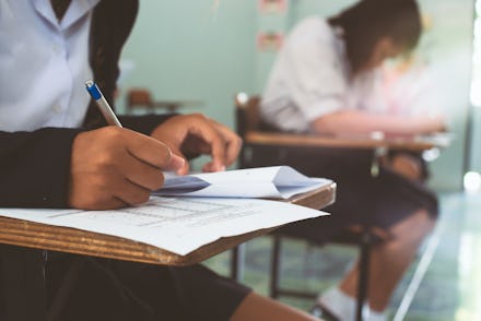 Uniform girl high school students doing exam at classroom with stress.