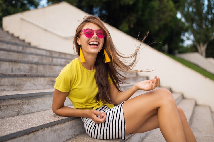 young attractive stylish smiling woman having fun in city park, positive, emotional, long hair, wear...