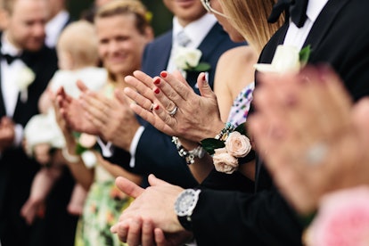 A closeup of the palms of wedding guests while they applaude