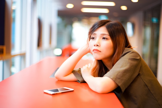 Lonely sad girl lying down on the table