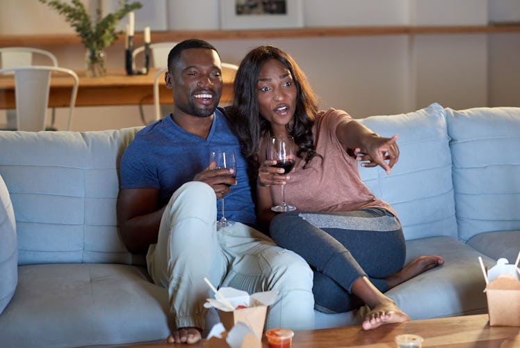 Black african couple watching movie television together having date night