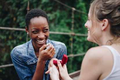 Woman proposing to her happy girlfriend outdoors love and marriage concept