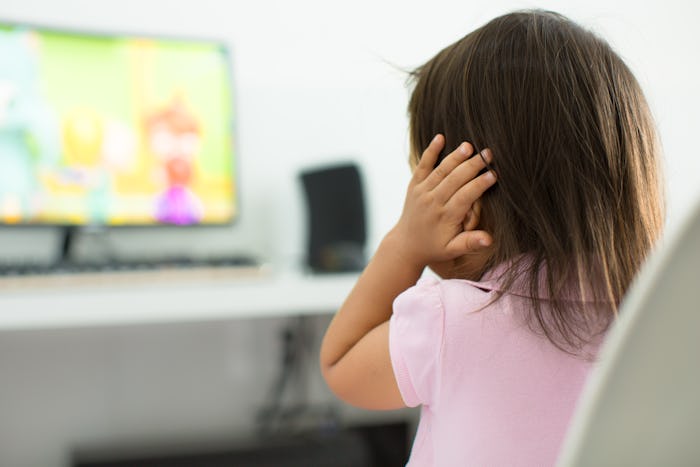 A terrified child, afraid of the loud sounds from the television. Autism.