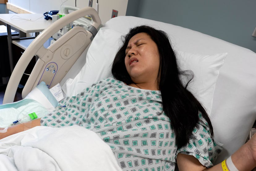Young Pregnant Asian Woman in Pain for Labor and Delivery inside Hospital
