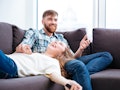 Portrait of a laughing couple having fun on the sofa at home