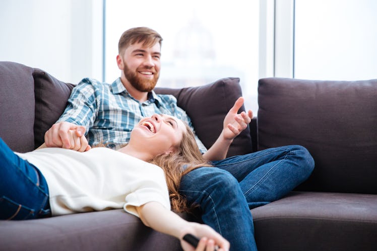 Portrait of a laughing couple having fun on the sofa at home