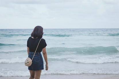 Alone woman looking at view on the beach.Depressed concept.