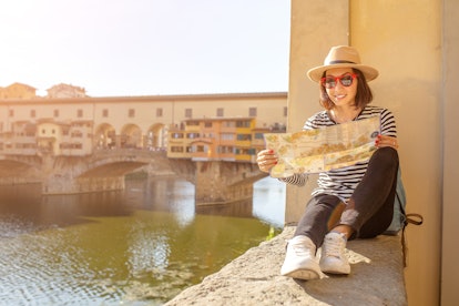 Happy traveler asian women on a vacation in Florence admiring view at the Ponte Vecchio famous landm...