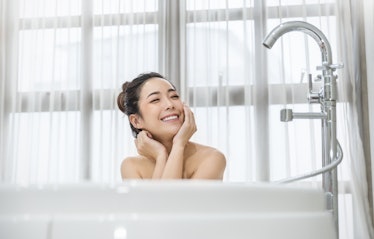 Portrait of young attractive happy asian girl takes a bath relax in the bathroom. Beauty woman in sp...