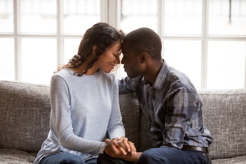 Black african married couple in love together at home. American woman and man embrace enjoy company ...