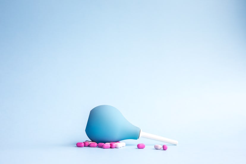 Blue douche lies and pills are pink and white around on a blue background. Women's health concept.