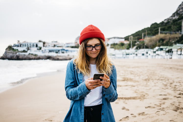 Woman outside texting her crush.