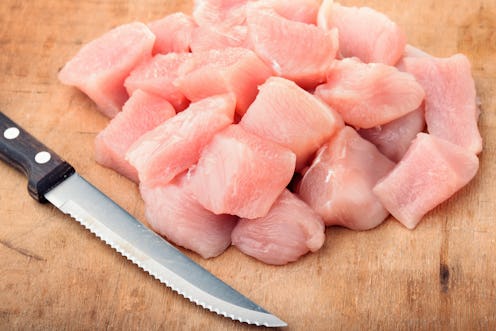 Close up of raw chicken fillet chunks on old wood surface
